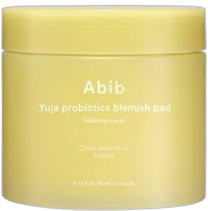 Abib Yuja Probiotics Blemish Pad Vitalizing Touch jar with yellow label and stacked cotton pads